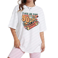 Woman wearing a white t-shirt with 'Take me back to the 90s' design in front of a white wall.